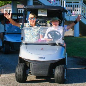 Two happy golfers in a cart.